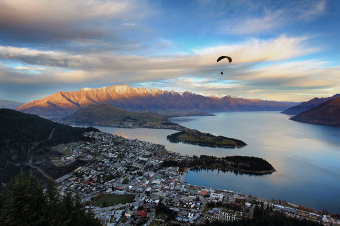 Wide angle photo of a beautiful coastal landscape with a paraglider - travel photography checklist