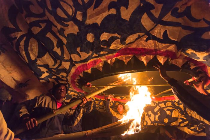 Night photography of men lighting a big lantern- travel photography checklist.