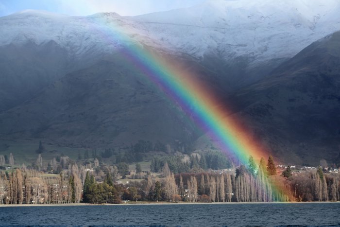 Photo of a rainbow over a beautiful coastal landscape - travel photography checklist