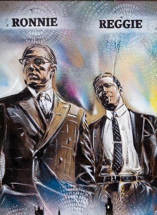 A graffiti mural of Ronnie and Reggie Kray. Travel photography shot list.