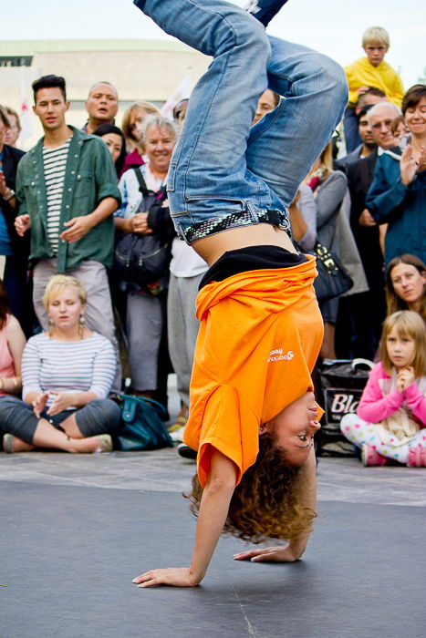 Photo of a person doing a handstand in front of a crowd of people.