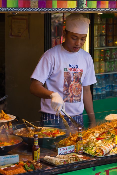 Man preparing Mexican food at a food stall in Camden Market. 