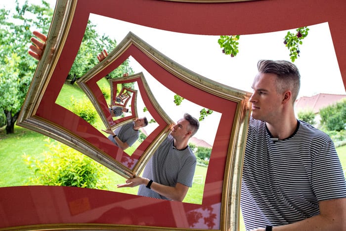 Photoshop ideas example of a droste effect shot of a man holding a photo frame, with the same image repeated within the frame and within that frame