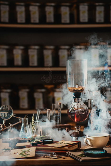 A still life of coffee brewing equipment on a wooden desk, in the style of a scientists workshop