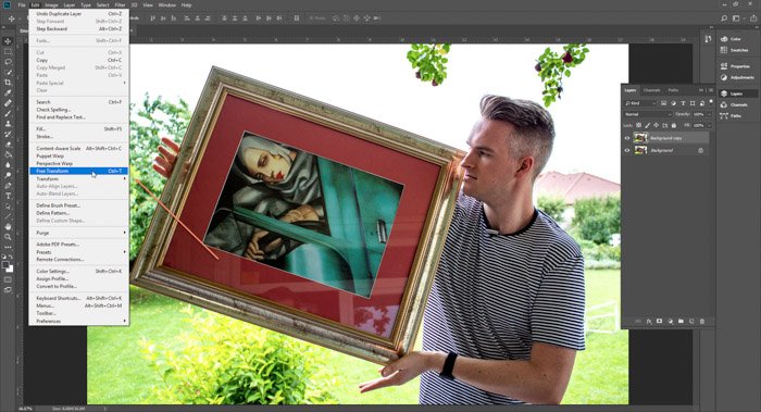 Screenshot of Photoshop editing a picture of a man holding a framed painting 