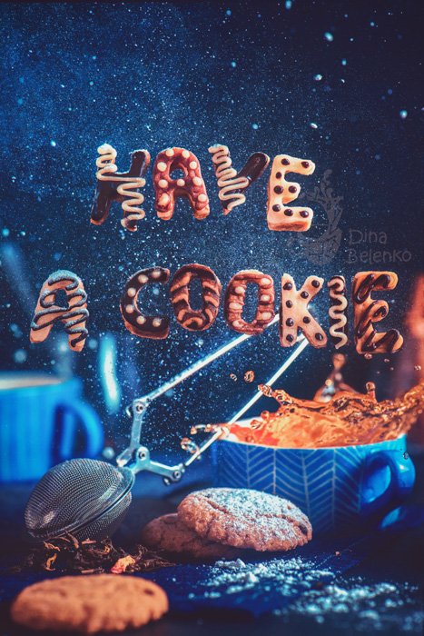 A cool food art shot featuring coffee cups, saucers, biscuits with food typography message 'have a cookie'.