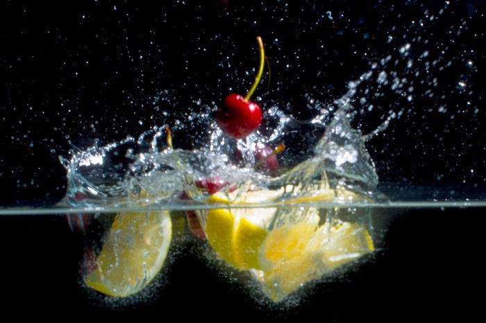 fruit photographed as it drops into water and creates a splash