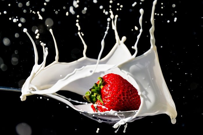 A slice of fruit photographed as it drops into water and creates a splash