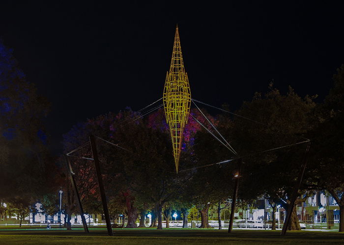 A street photography shot of a colored structure glowing at night 