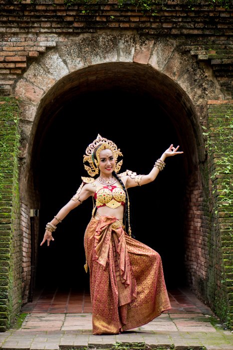 Photo of a Thai Dancer standing in front of a tunnel - How to Create a Black Background For Photography