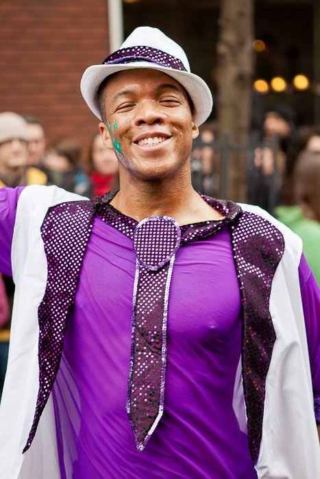 A carnival photography shot of a man in purple smiling at the camera