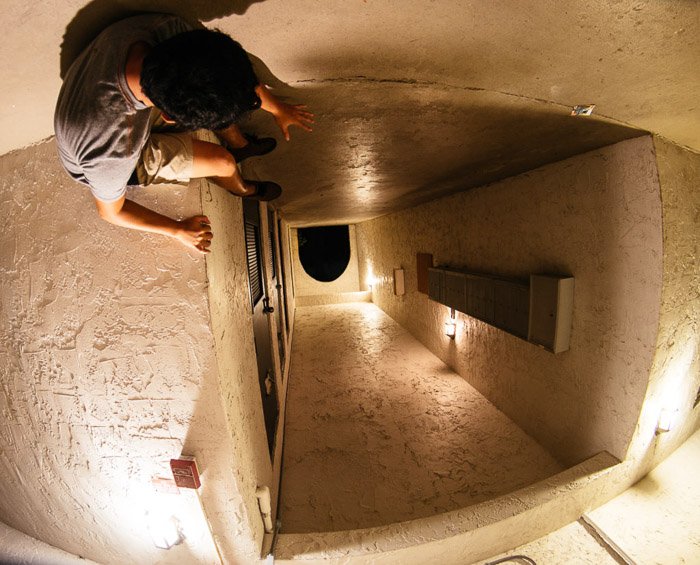 A forced perspective shot of a man looking down on an upside corridor