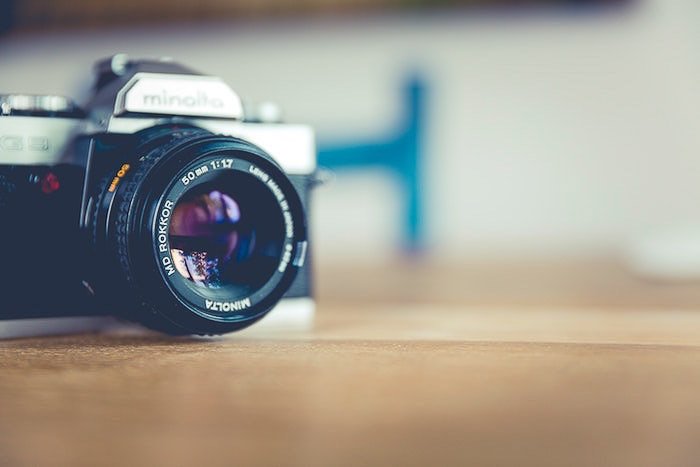 A camera on a wooden table with soft blurry background