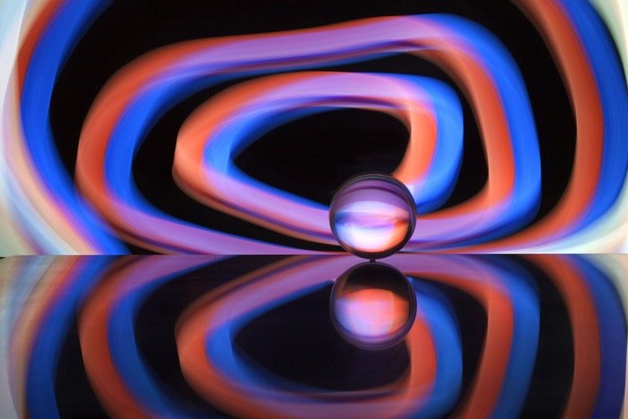 A glass illuminated with many colours up using a smartphone for light painting background - creative photography ideas