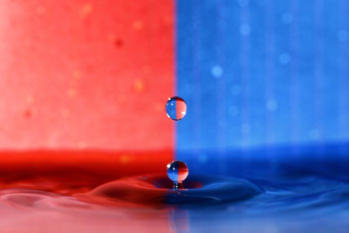 A red and blue background with a water drop photography splash in the foreground