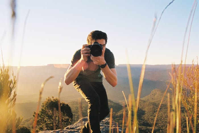 A man pointing his camera at the photographer 