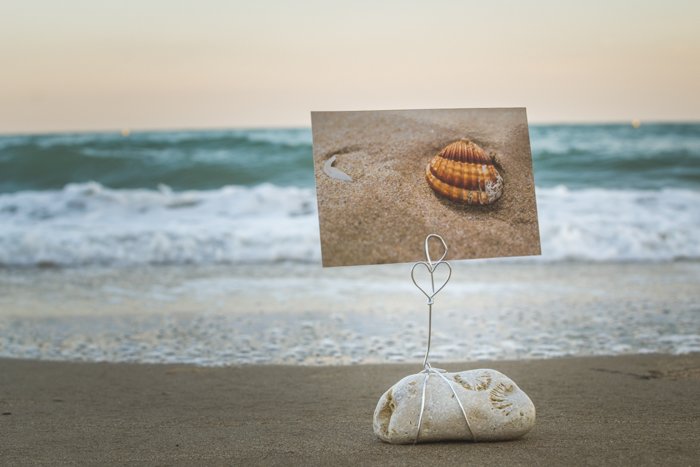 A DIY photo holder made from beach stones on the sand, a fabulous seascape in the background