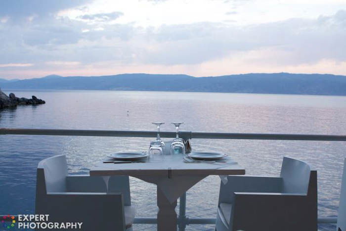 A dining table set up by the sea at evening time 