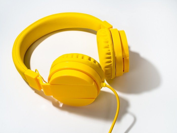 A product photography styling example of a pair of yellow headphones on white background