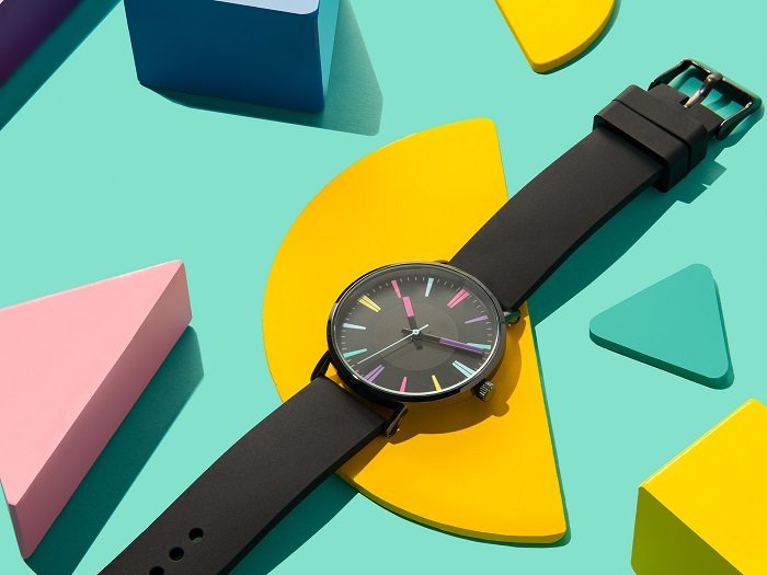 A product photography styling example of a digital watch displayed on bright shapes