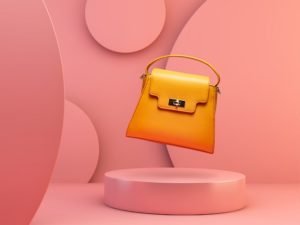 Cool product photography styling example of a yellow handbag against a funky pink background