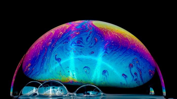 macro photo of a soap bubble in the colors of a rainbow