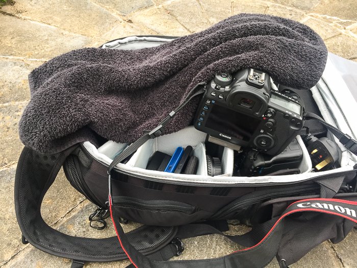 Overhead view of a towel resting on a dslr camera bag 