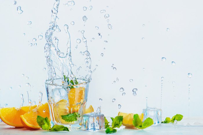 一个创造性的食物摄影设置与桔子和水在白色背景飞溅