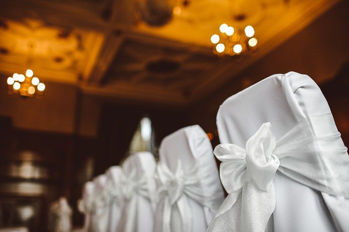 A row of chairs decorated for a wedding ceremony. Wedding photography gear
