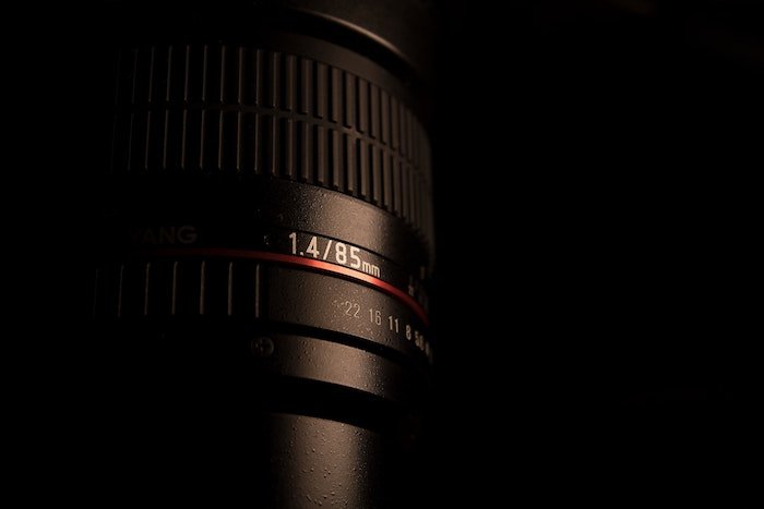 Close up photo of a 1.4/85mm lens on black background