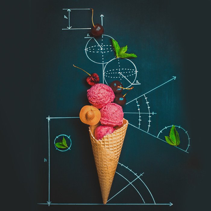 A creative still life flat lay idea with an ice-cream cone on a chalkboard surface