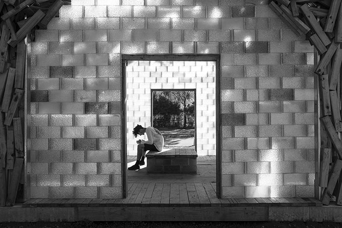 A black and white shot of a visitor in The Glass Pavilion 2017 by Gregor Kregar, street photography lighting