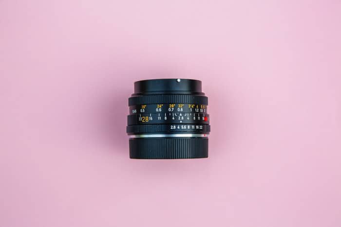 Overhead photo of a DSLR camera lens on pink background -how to create a bokeh background