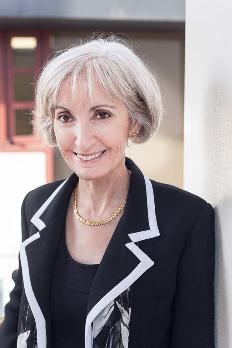 A corporate portrait of a woman in a business suit in an office setting