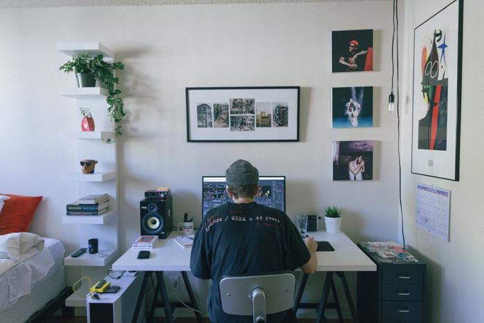 A man editing photos on a laptop in a home office