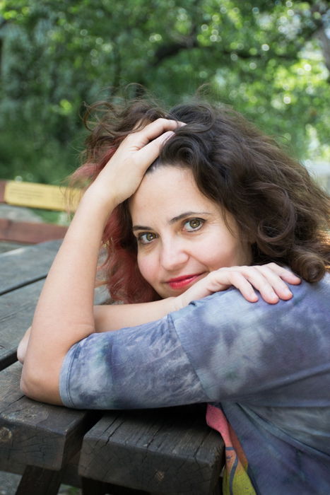 woman in grey leaning on wooden picnic table 4:3 photo