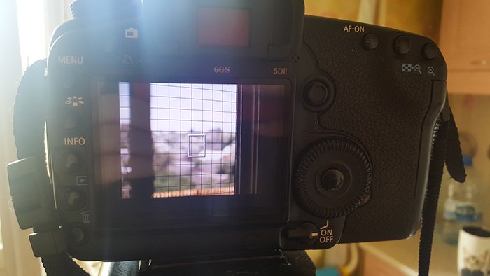 A DSLR camera pointed towards a wire grid