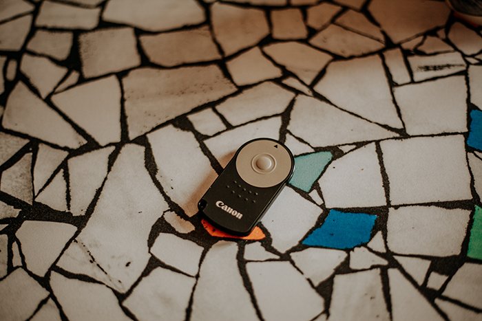 A canon camera remote on a tile floor