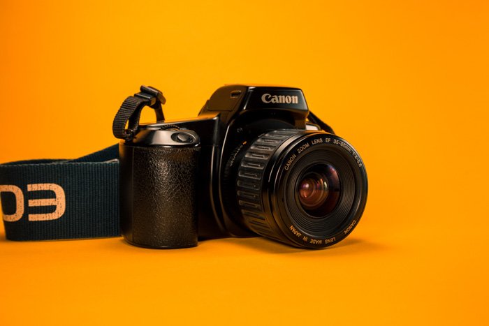 a canon DSLR camera on a bright orange surface