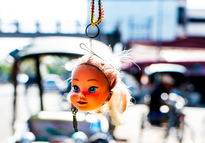 A dolls head hanging from a car or bike