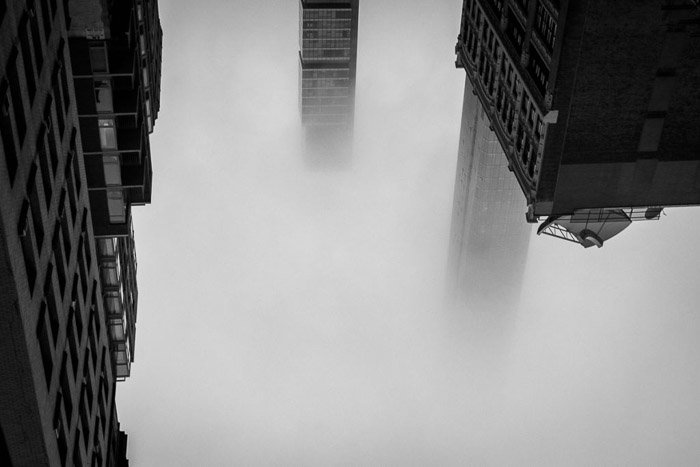 Architecture photography made abstract: Atmospheric shot of three buildings emerging from Manhattan in fog. New York, NY, USA