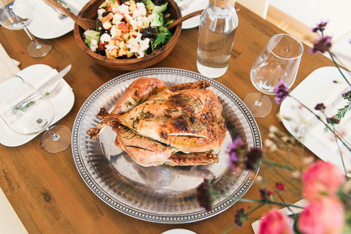 Overhead shot of a roast chicken and other dinner items 