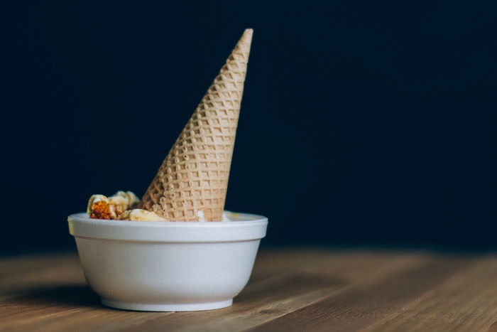 An ice cream cone in a bowl against a dark background