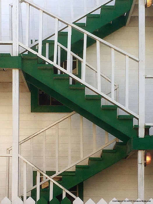 一个绿色的室外楼梯，对角线创建了一个Z图案用iPhone摄影相机拍摄