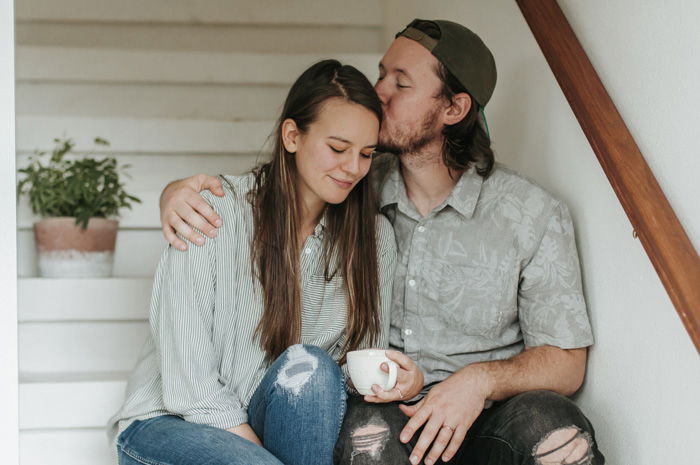 A portrait of a couple kissing while sitting on a stairway, taken with ISO 200-400