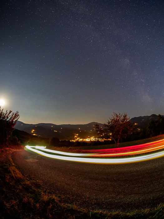 A nocturnal landscape including light trails from my car running on the road in front of me.