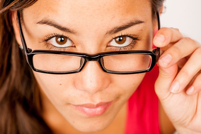 close up photography composition of a woman in a red shirt and glasses looking up