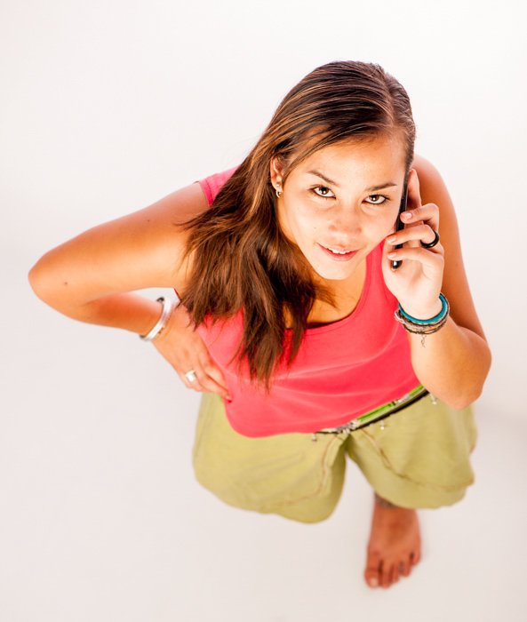 A photography composition example of a brunette woman in a red shirt speaking on her cellphone looking up