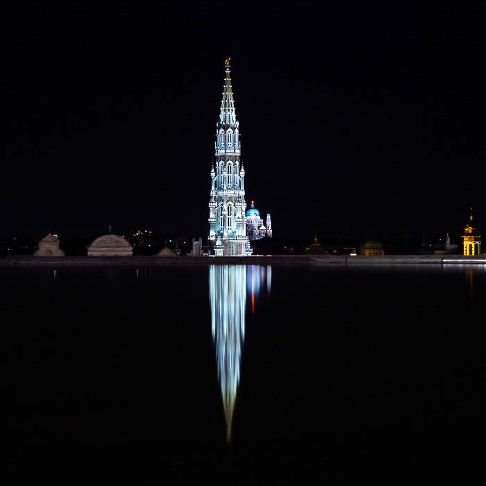 Long exposure of Town Hall tower in Grand Place and the Basilica of the Sacred Heart (Brussels) reflecting in the fountain in Mons des Arts. Sony RX10.