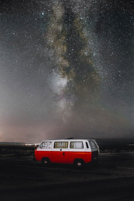 Striking shot of the milky way at night over a red van